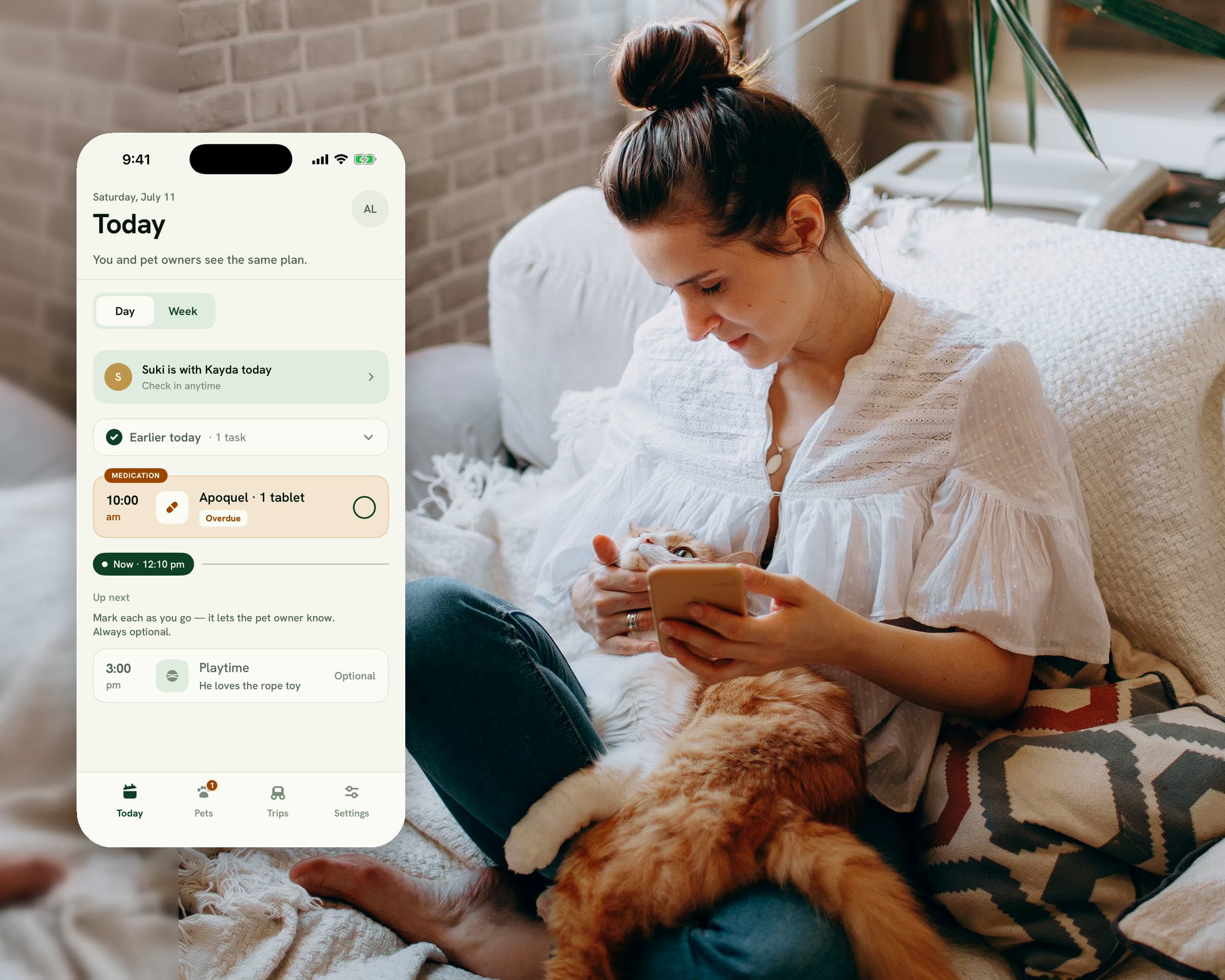 A woman in a bright boho living room checks her phone with a ginger cat on her lap; beside them, the Pawmise Today screen shows 'Suki is with Kayda today' and an amber medication reminder